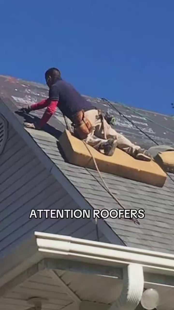 Load video: Contractor sets down a durable roofing mat and kneels on it, ensuring a secure and professional roof installation. Trusted roofing services for lasting protection!